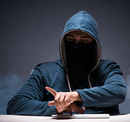 Computer hacker working in dark roomの写真素材