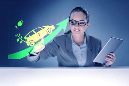 Electric car concept with businesswoman pressing buttonの写真素材