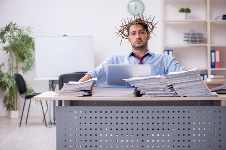 Young male employee wearing prickly wreath on headの写真素材