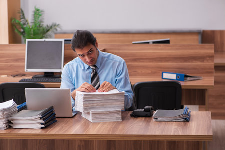 Young male employee unhappy with excessive workの写真素材