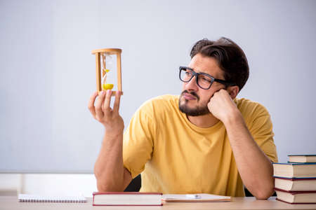 Young male student in time management concept