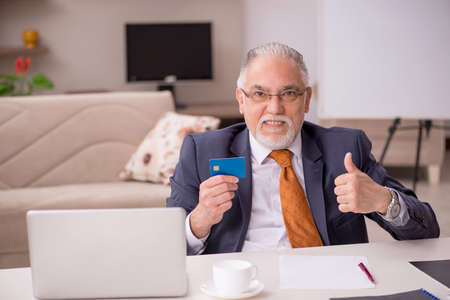 Old male employee working from home during pandemic