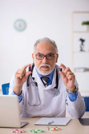 Old male doctor pharmacist working at the labの写真素材