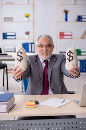 Old male employee in remuneration conceptの写真素材