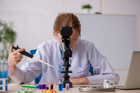 Young female chemist in drugs synthesis conceptの写真素材