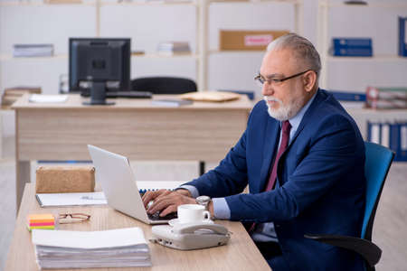 Old male employee working in the officeの写真素材
