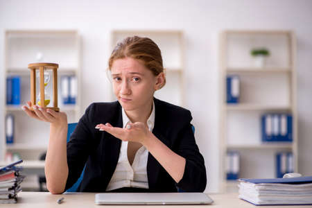 Young female employee in time management concept