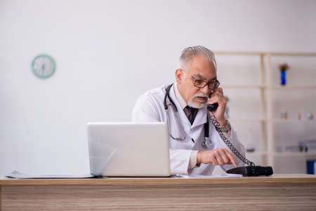 Old male doctor working at the hospitalの写真素材