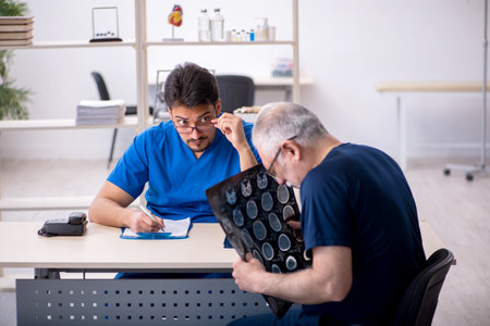 Old man visiting young male doctor radiologistの写真素材