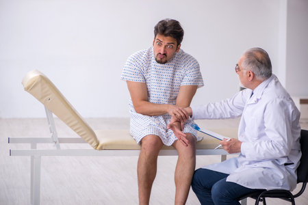 Old male doctor psychiatrist examining young male patientの写真素材