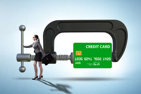 Concept of credit card debt with clamp and businesswomanの写真素材