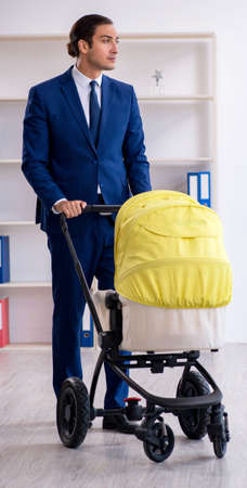 Young father looking after newborn in the office