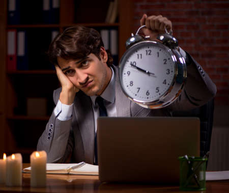 The businessman working late in office with candle lightの写真素材