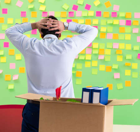 Man collecting his stuff after redundancy in the office with man