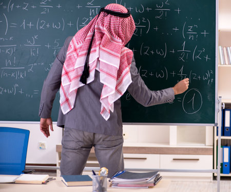 The arab teacher wearing suit in front of chalkboardの写真素材