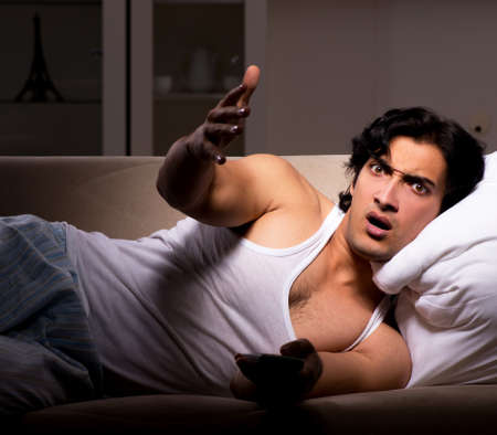 The young man suffering at home night timeの写真素材