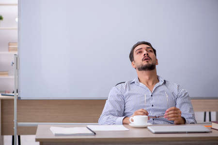 Young male teacher in the classroomの写真素材