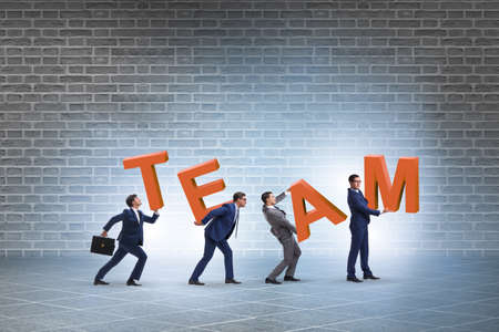 Teamwork concept with people carrying team lettersの写真素材