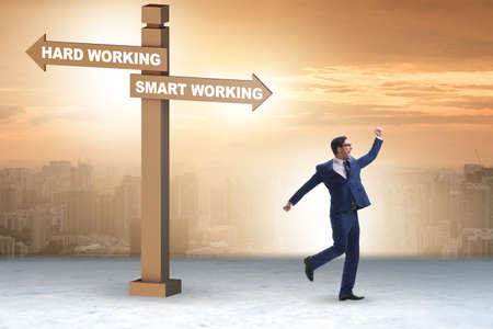 Businessman at the crossroads on working smart or hardの写真素材