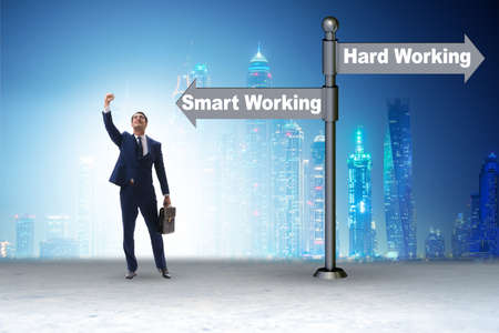 Businessman at the crossroads on working smart or hardの写真素材