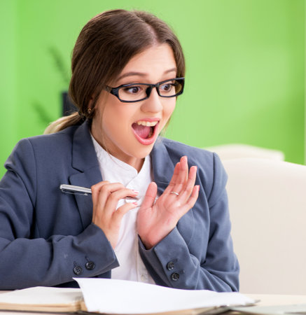 Young female employee very busy with ongoing paperworkの写真素材