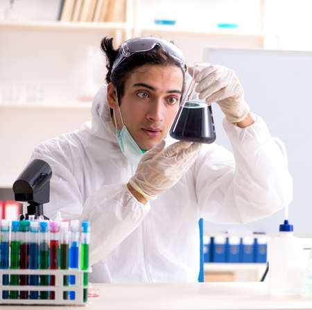The young handsome chemist working in the lab