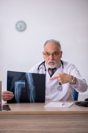 Old male doctor radiologist working at the hospitalの写真素材