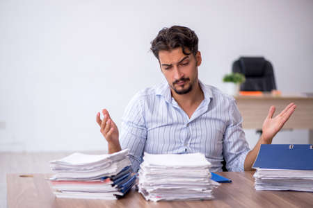 Young male employee and too much work in the office