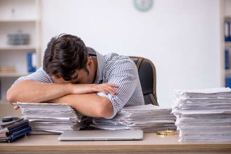 Young male employee unhappy with excessive work in the office