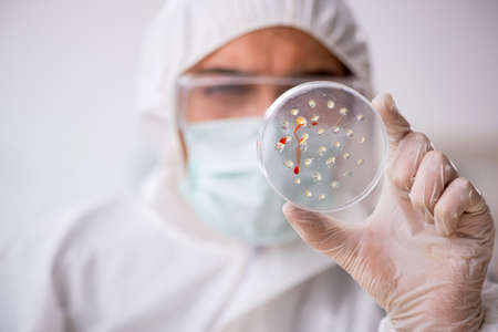 Young male chemist in drugs synthesis conceptの写真素材