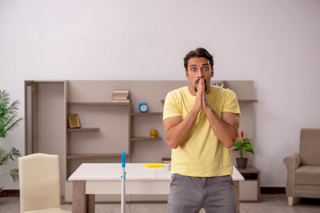 Young man doing housework at homeの写真素材