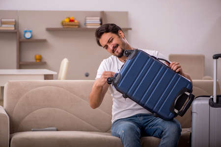 Young man preparing for trip at homeの写真素材