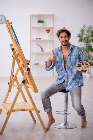 Young man enjoying painting at the studioの写真素材