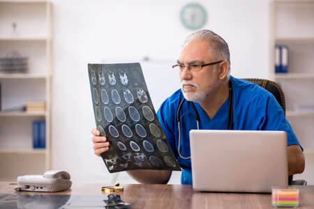 Old male doctor radiologist working in the clinic
