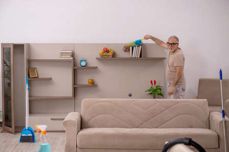 Old man doing housework at home