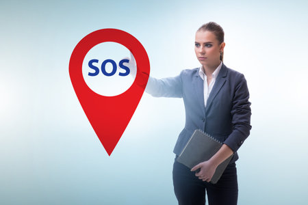Businesswoman pressing SOS button in case of dangerの写真素材