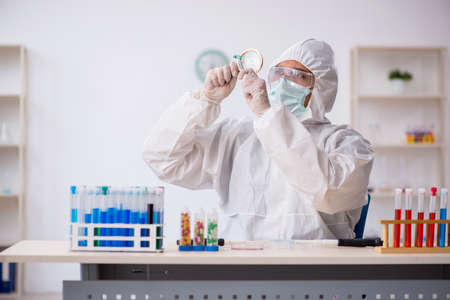 Young male chemist in drugs synthesis conceptの写真素材