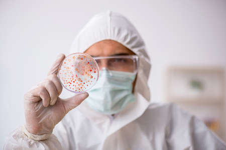 Young male chemist in drugs synthesis conceptの写真素材