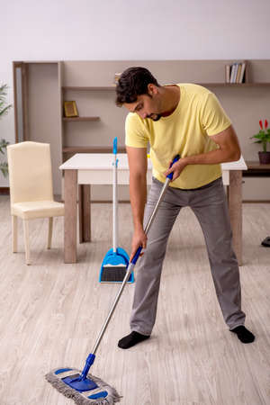 Young man doing housework at home