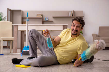 Young man doing housework at homeの写真素材