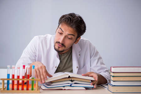 Young male chemist teacher in front of whiteboardの写真素材