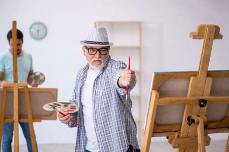 Two male painters enjoying painting at homeの写真素材