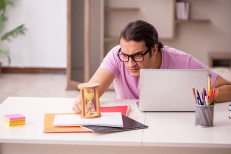 Young male student in time management concept