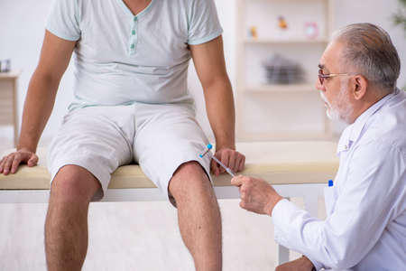 Young male patient visiting old male doctor neurologistの写真素材