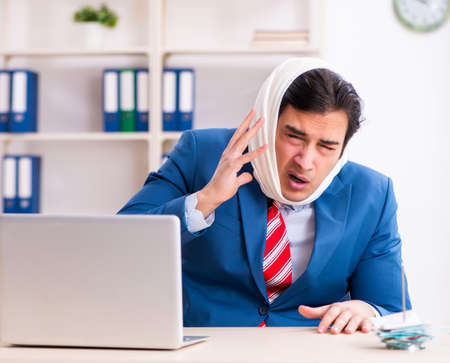 Young male employee suffering in the officeの写真素材