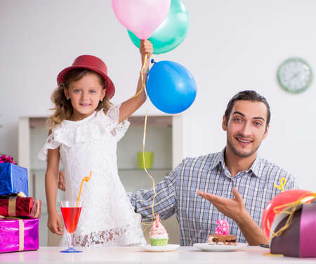 Father celebrating birthday with his daughterの写真素材