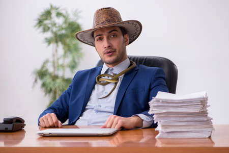 Young cowboy businessman working at workplaceの写真素材