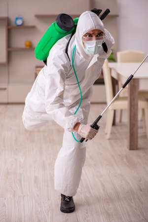 Young male contractor doing pest control at homeの写真素材