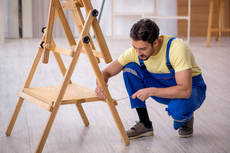 Young male repairman repairing easel at homeの写真素材