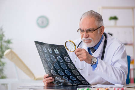 Old male doctor radiologist working in the clinic